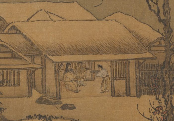 Detail of an ink landscape on silk: a thatched riverside cottage under snow, its open side showing three small figures seated together, one offering a tray.